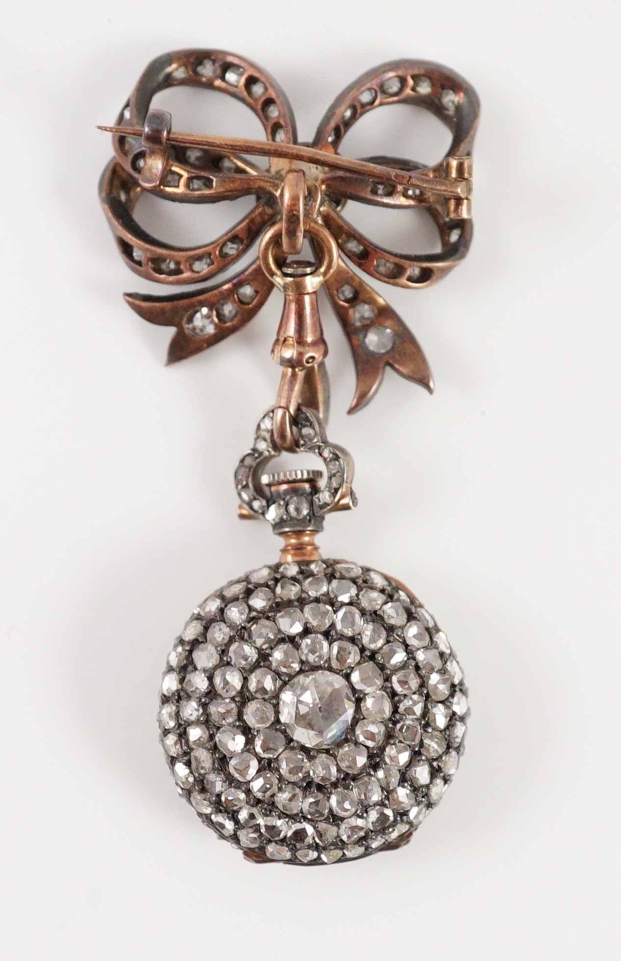 A late 19th century/early 20th century French 18ct gold and rose cut diamond encrusted fob lapel watch, on a rose cut diamond set ribbon bow suspension brooch